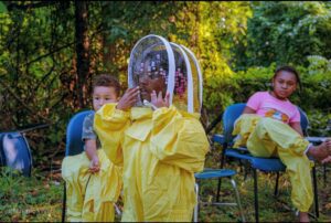 young girl wearing a bee protection suit
